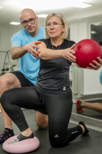 Fizjoterapeuta Konin pokazuje ćwiczenia na zamrożony bark